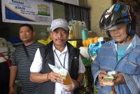 Pimpinan Perum Bulog Kanwil Papua, Ahmad Mustari saat menujukan MinyaKita ke Pembeli di Pasar Hamadi Jayapura, Jumat (1/5).