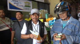 Pimpinan Perum Bulog Kanwil Papua, Ahmad Mustari saat menujukan MinyaKita ke Pembeli di Pasar Hamadi Jayapura, Jumat (1/5).